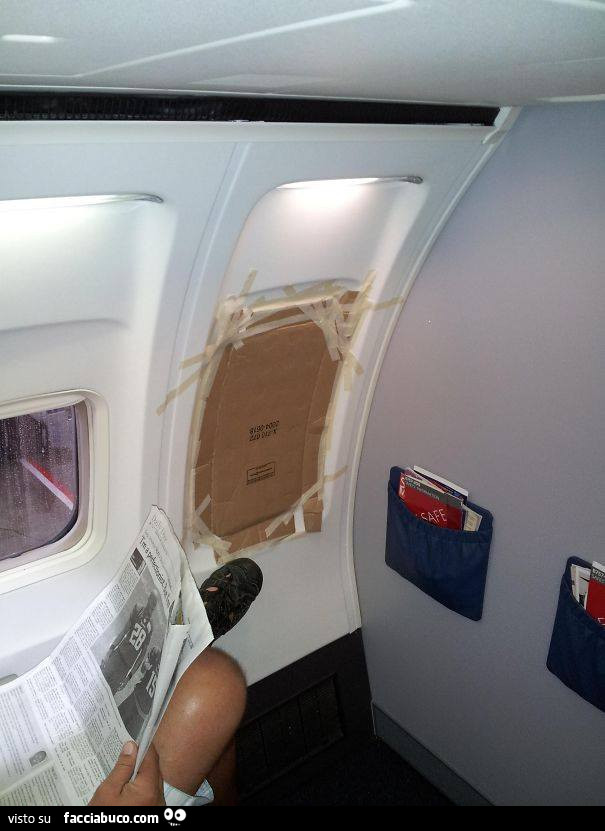 Finestrino dell'aereo coperto con cartellone e scotch